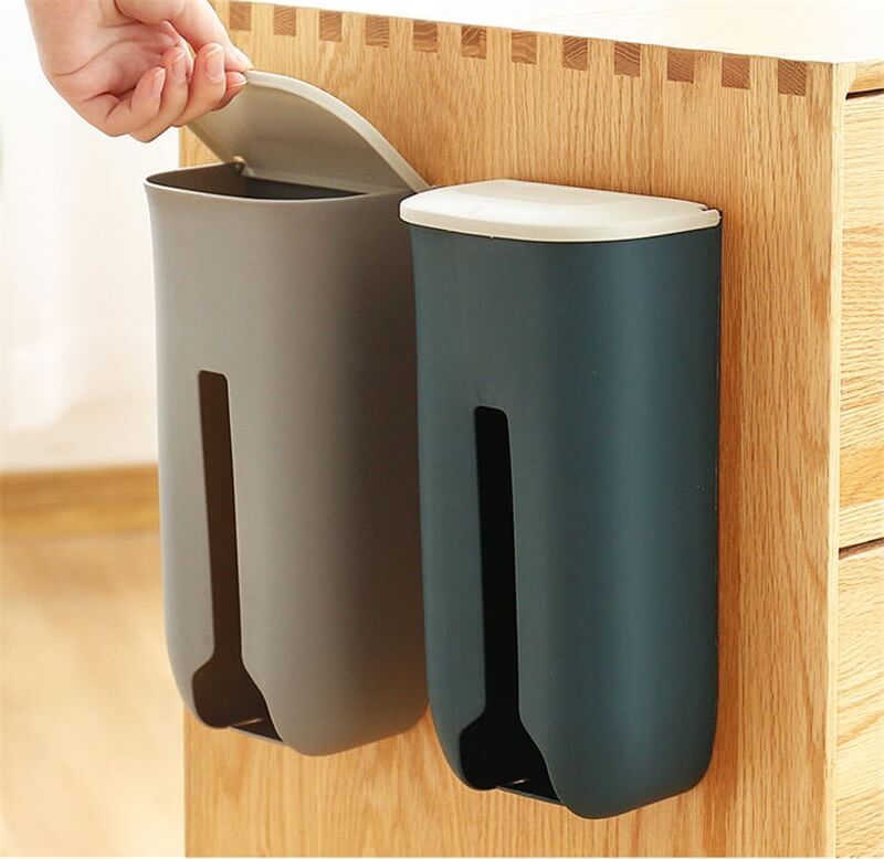Two wall-mounted trash cans, one gray and one blue, attached to a wooden cabinet.