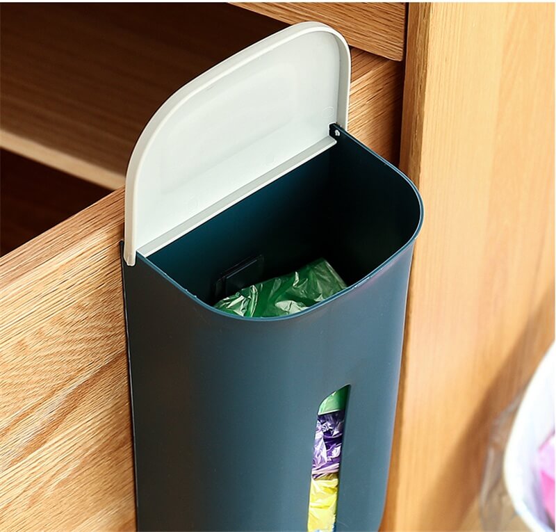 Wall-mounted trash can with a white lid on a wooden surface