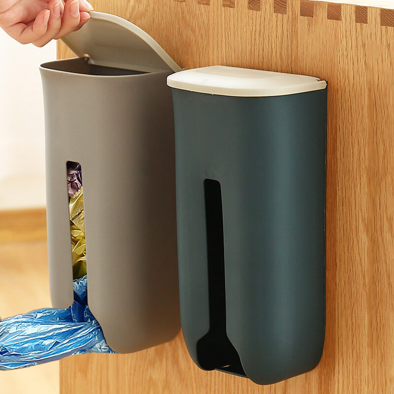 Wall-mounted trash can with a hand reaching to open it, set against a wooden background.